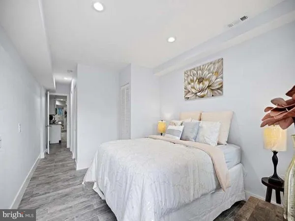 a bedroom with bed and a painting on the wall