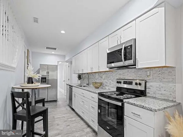 a kitchen with a stove a sink and a microwave