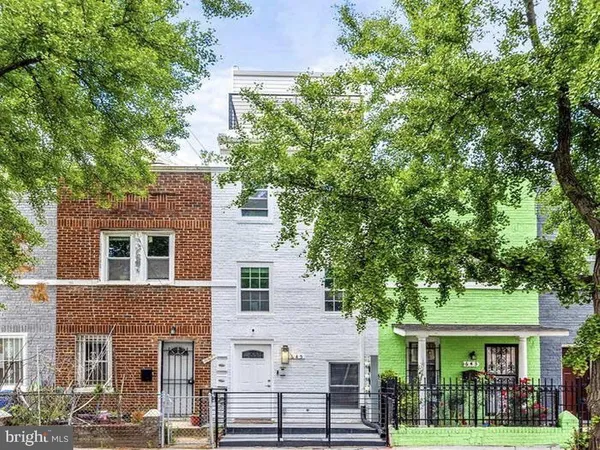 front view of a brick house with a tree