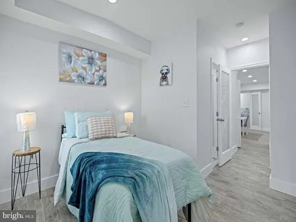 a spacious bedroom with a bed and painting on the wall