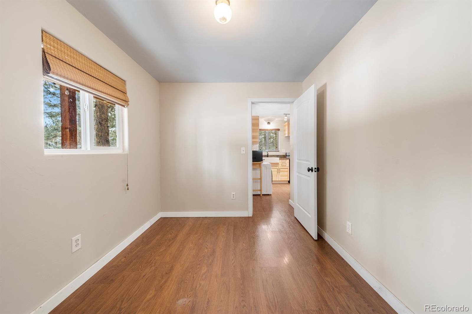 437 Kutsu Ridge Road Florissant, CO 80816 - Photo 10 of 24 a view of a hallway with wooden floor and a bathroom