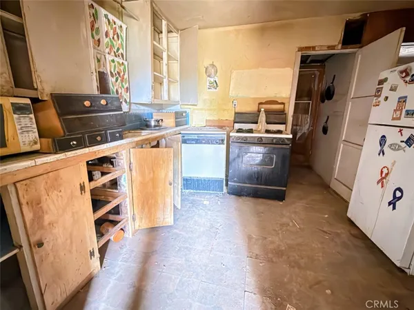 a kitchen with a refrigerator stove and white cabinets