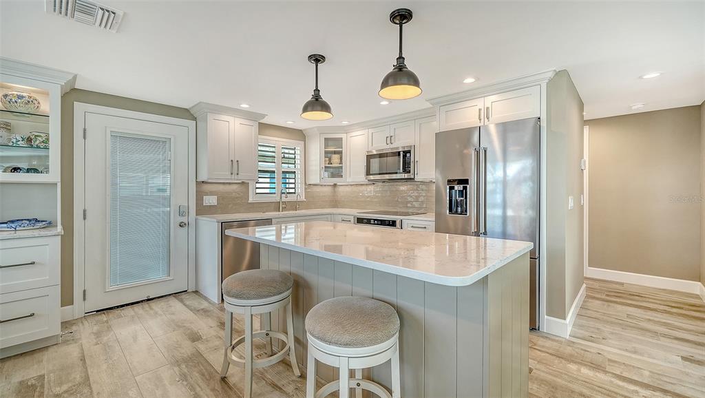 6140 Midnight Pass Road, Unit B6 Sarasota, FL 34242 - Photo 15 of 63 a large kitchen with a table and chairs