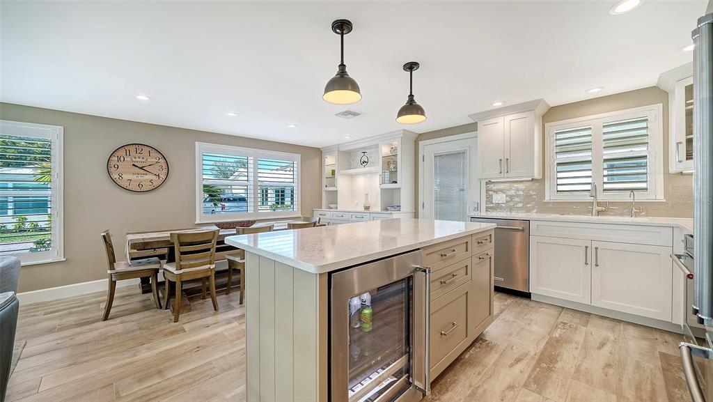 6140 Midnight Pass Road, Unit B6 Sarasota, FL 34242 - Photo 17 of 63 a open kitchen with a sink a stove a dining table and chairs with wooden floor