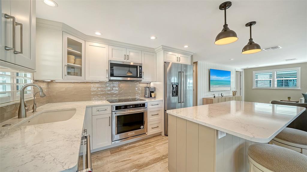 6140 Midnight Pass Road, Unit B6 Sarasota, FL 34242 - Photo 18 of 63 a kitchen with stainless steel appliances granite countertop a sink a stove a oven a dining table and chairs