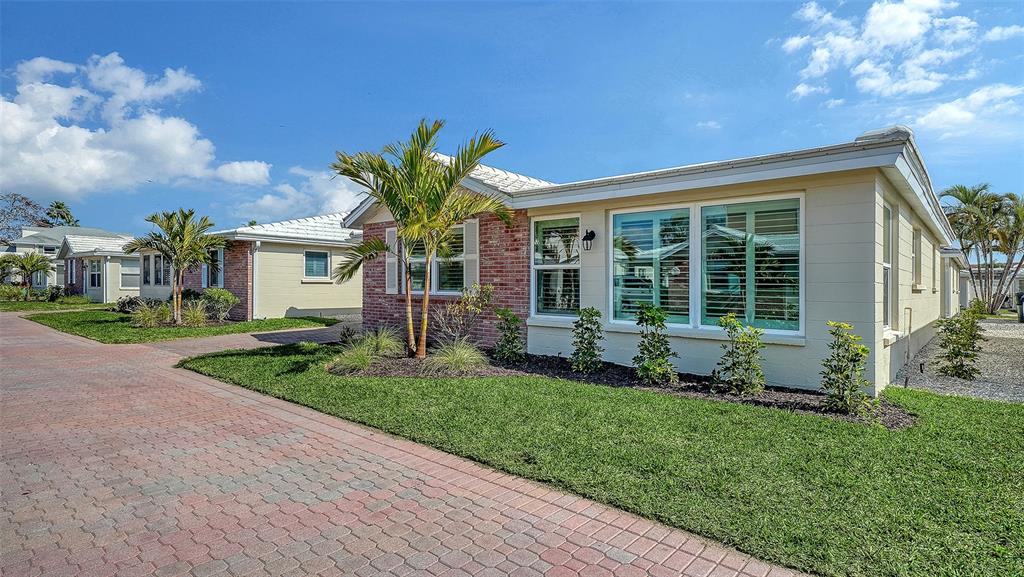 6140 Midnight Pass Road, Unit B6 Sarasota, FL 34242 - Photo 2 of 63 a front view of a house with a yard and potted plants
