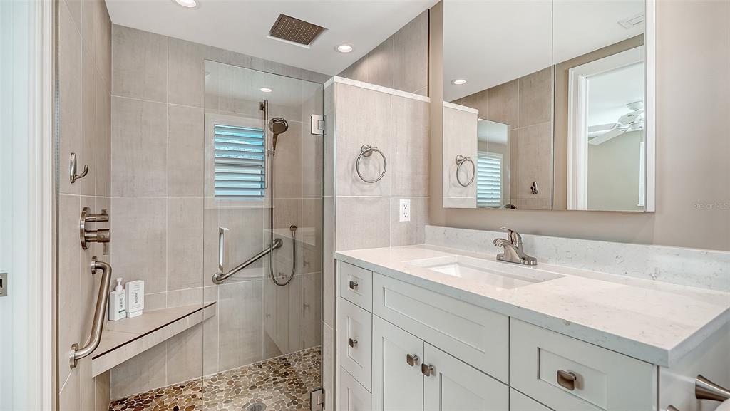 6140 Midnight Pass Road, Unit B6 Sarasota, FL 34242 - Photo 28 of 63 a bathroom with a shower sink vanity and mirror