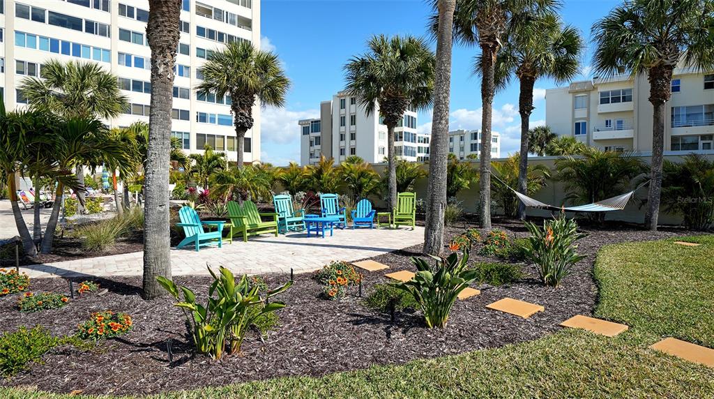 6140 Midnight Pass Road, Unit B6 Sarasota, FL 34242 - Photo 49 of 63 a view of a patio with table and chairs potted plants and palm trees