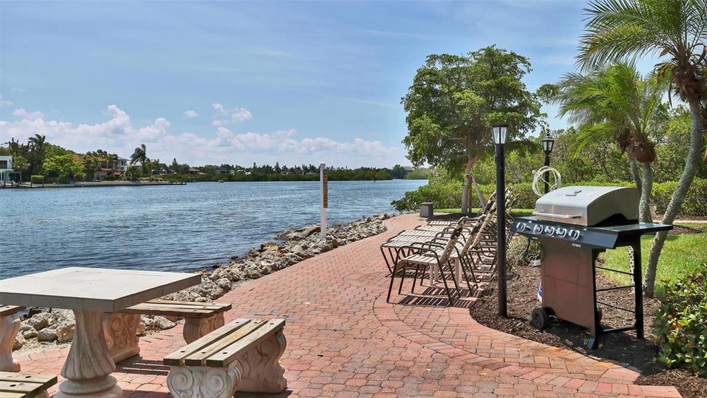 6140 Midnight Pass Road, Unit B6 Sarasota, FL 34242 - Photo 61 of 63 a view of a lake with table and chairs potted plants and lake view