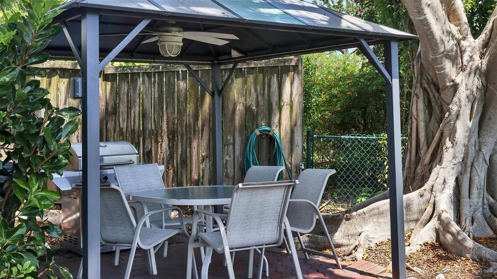 6140 Midnight Pass Road, Unit B6 Sarasota, FL 34242 - Photo 62 of 63 a view of backyard with a table and chairs and potted plants