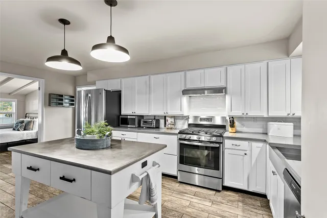a kitchen with stainless steel appliances a sink a stove and cabinets