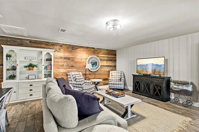 a living room with furniture and a wooden floor