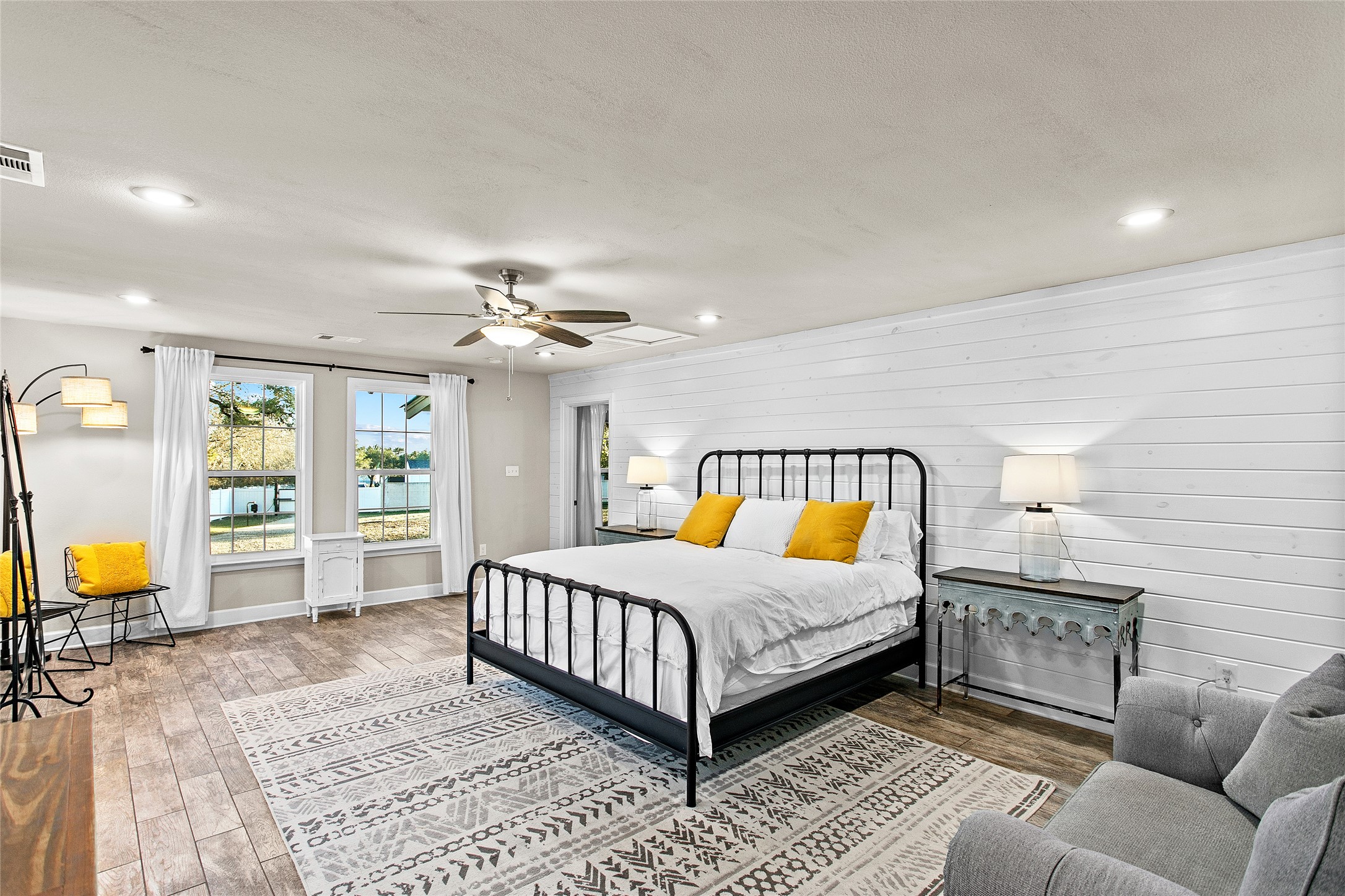 200 Creek Road Dripping Springs, TX 78620 - Photo 13 of 40 a bedroom with a large bed a chandelier and windows