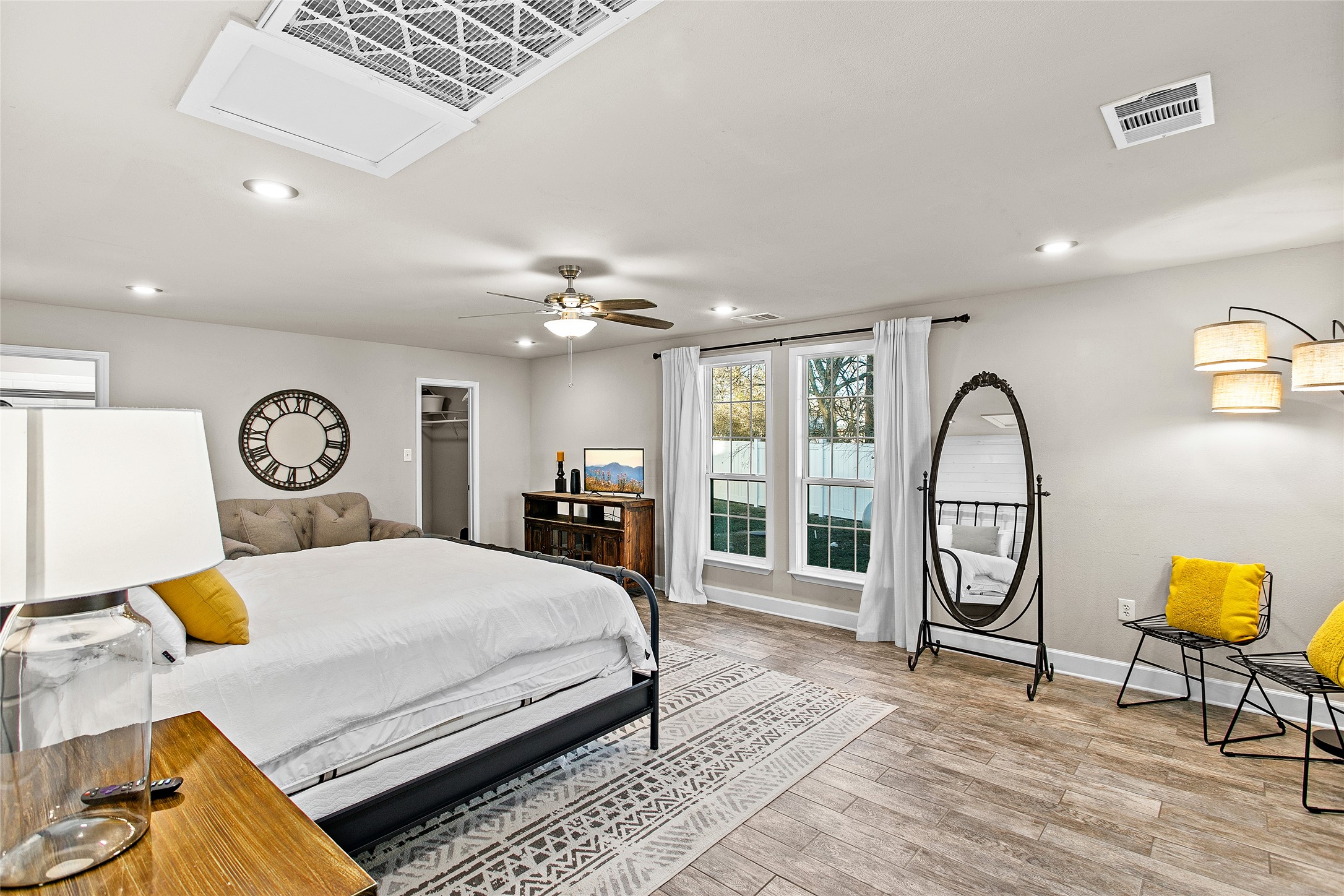 200 Creek Road Dripping Springs, TX 78620 - Photo 14 of 40 a bedroom with a bed a dresser next to a large window with the outer view and chair