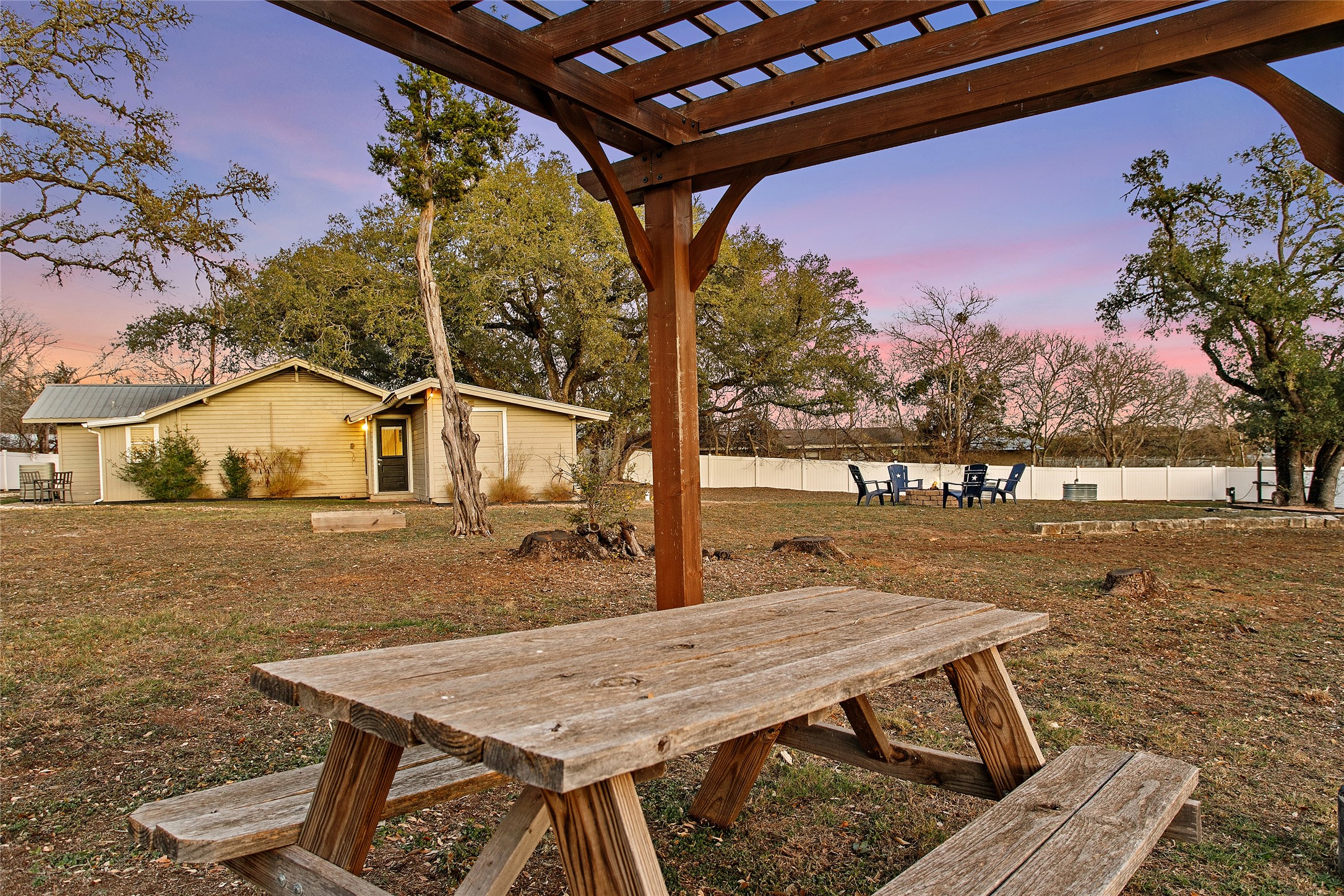 200 Creek Road Dripping Springs, TX 78620 - Photo 38 of 40 a view of a patio with table and chairs with wooden floor and fence