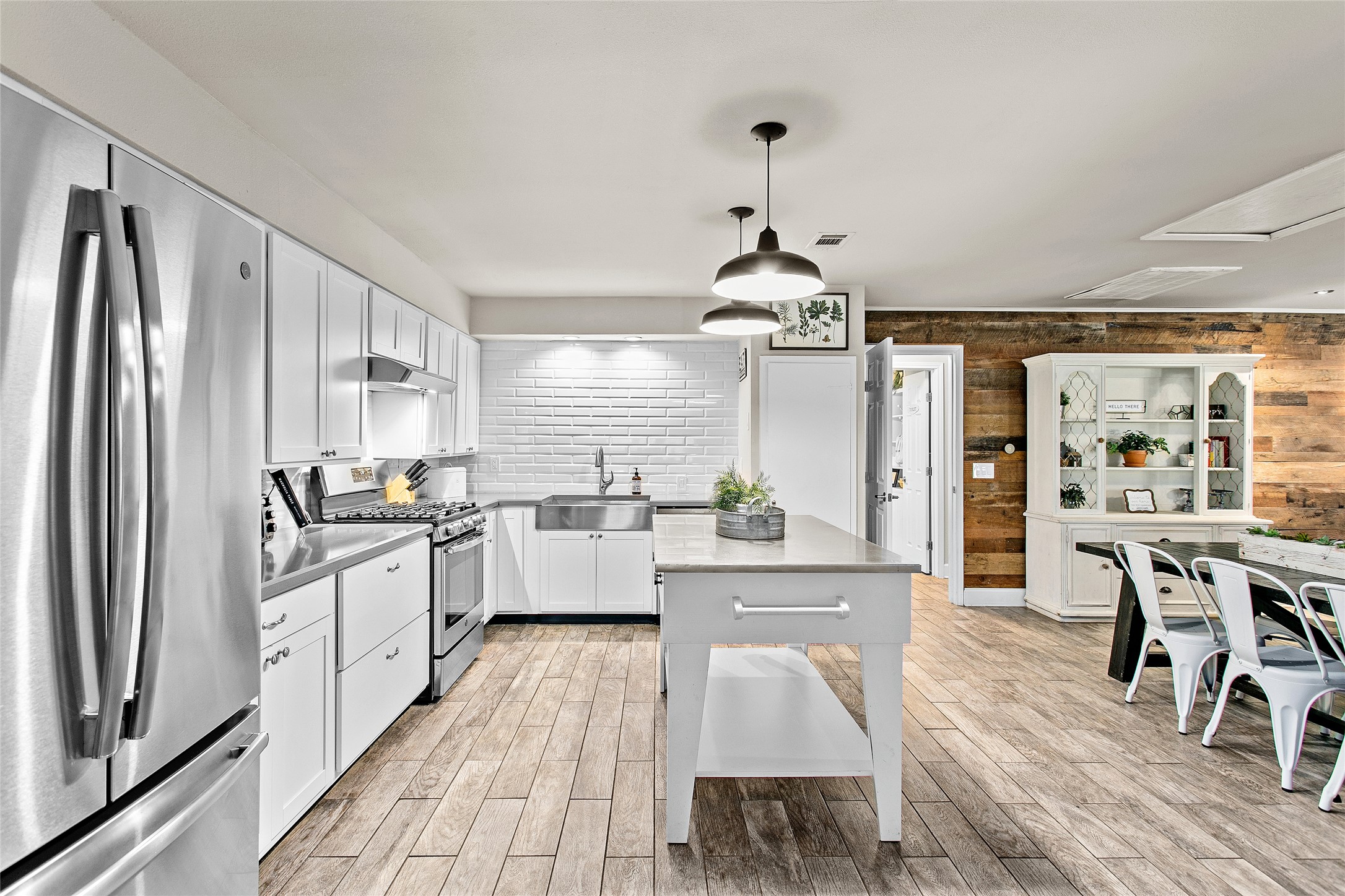 200 Creek Road Dripping Springs, TX 78620 - Photo 9 of 40 a kitchen with stainless steel appliances a dining table chairs stove and refrigerator