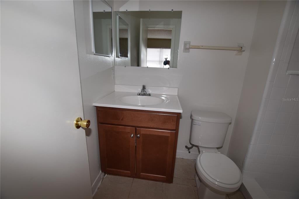 3173 Split Willow Drive Orlando, FL 32808 - Photo 15 of 16 a bathroom with a toilet sink and mirror