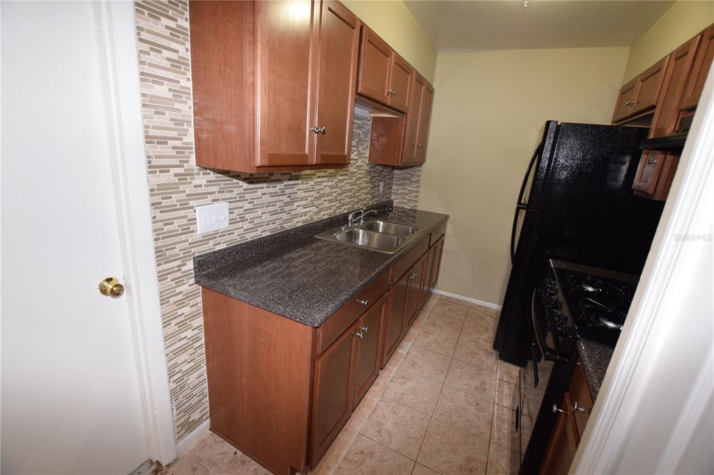 3173 Split Willow Drive Orlando, FL 32808 - Photo 9 of 16 a kitchen with a sink stove and microwave