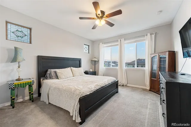 a spacious bedroom with a bed and a television