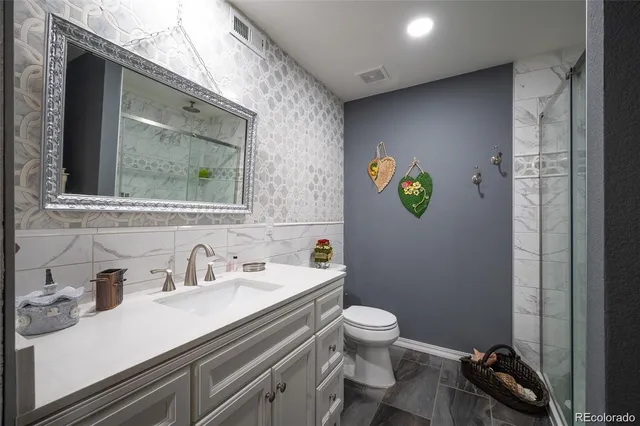 a bathroom with a sink mirror vanity and toilet