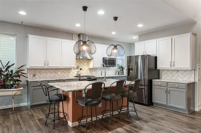 a kitchen with a table chairs refrigerator and cabinets