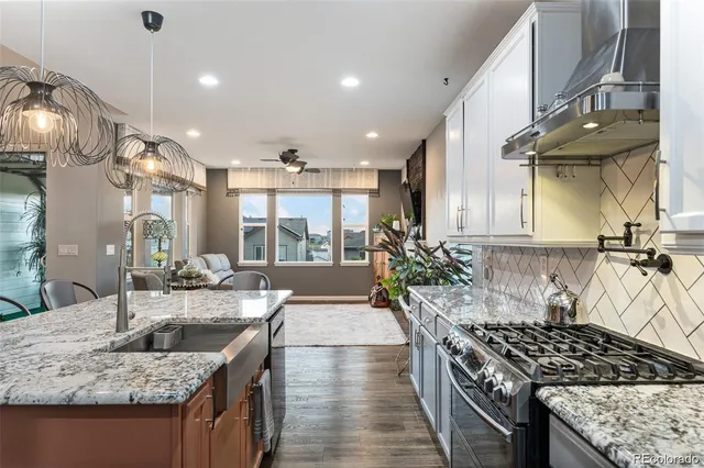 a kitchen with stainless steel appliances granite countertop a sink stove and refrigerator