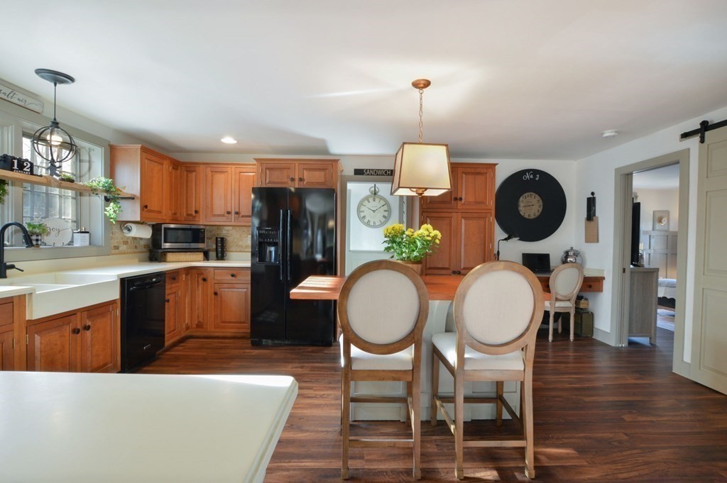 3 Academy Road Sandwich, MA 02563 - Photo 13 of 41 a kitchen with stainless steel appliances a dining table chairs and a refrigerator