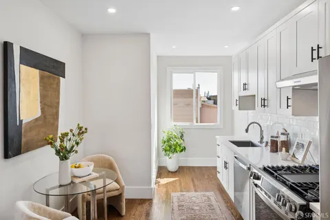 a kitchen with stainless steel appliances granite countertop a refrigerator a stove a sink and white cabinets