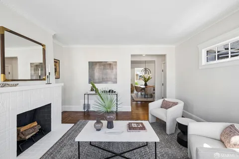 a living room with furniture a large window and a fireplace