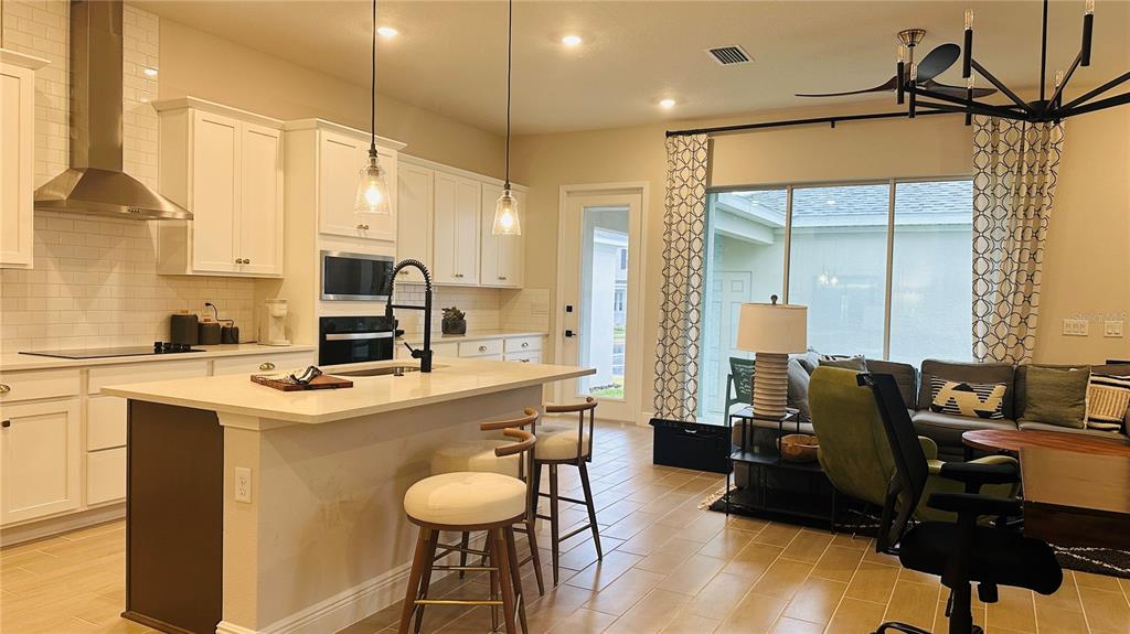 16450 Hamlin View Street Winter Garden, FL 34787 - Photo 9 of 32 a kitchen with stainless steel appliances granite countertop a sink a stove and a refrigerator