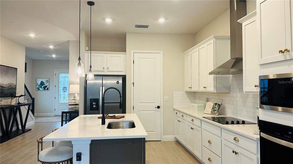 16450 Hamlin View Street Winter Garden, FL 34787 - Photo 10 of 32 a kitchen with granite countertop a sink stove and cabinets