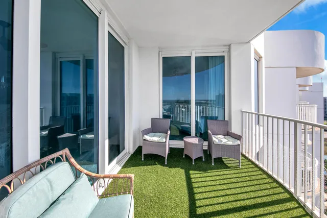 a balcony with chairs and a yard