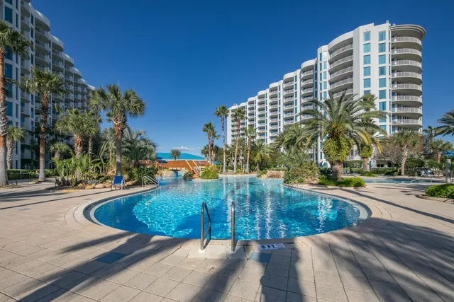 a view of a tall building with a lawn chair and palm trees
