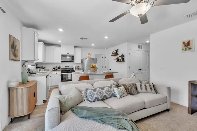 a living room with furniture and kitchen view