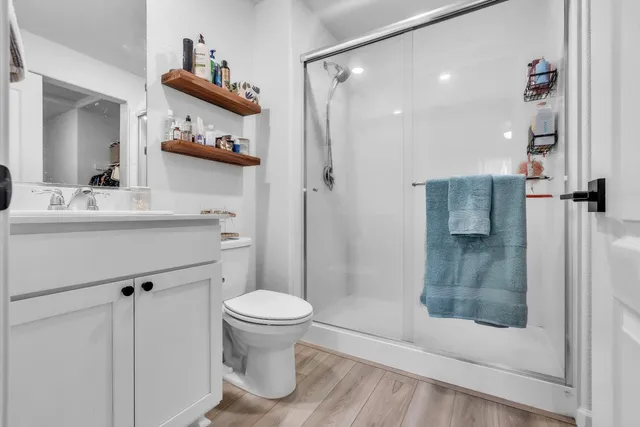 a bathroom with a sink a toilet and shower