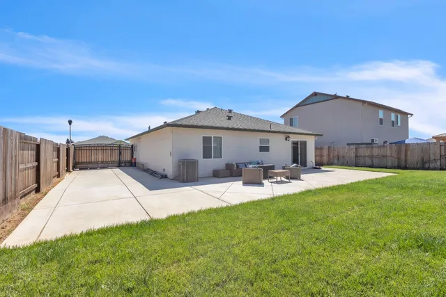 a view of a house with backyard and sitting area