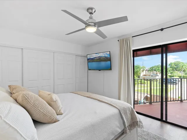 a bedroom with a bed and a ceiling fan