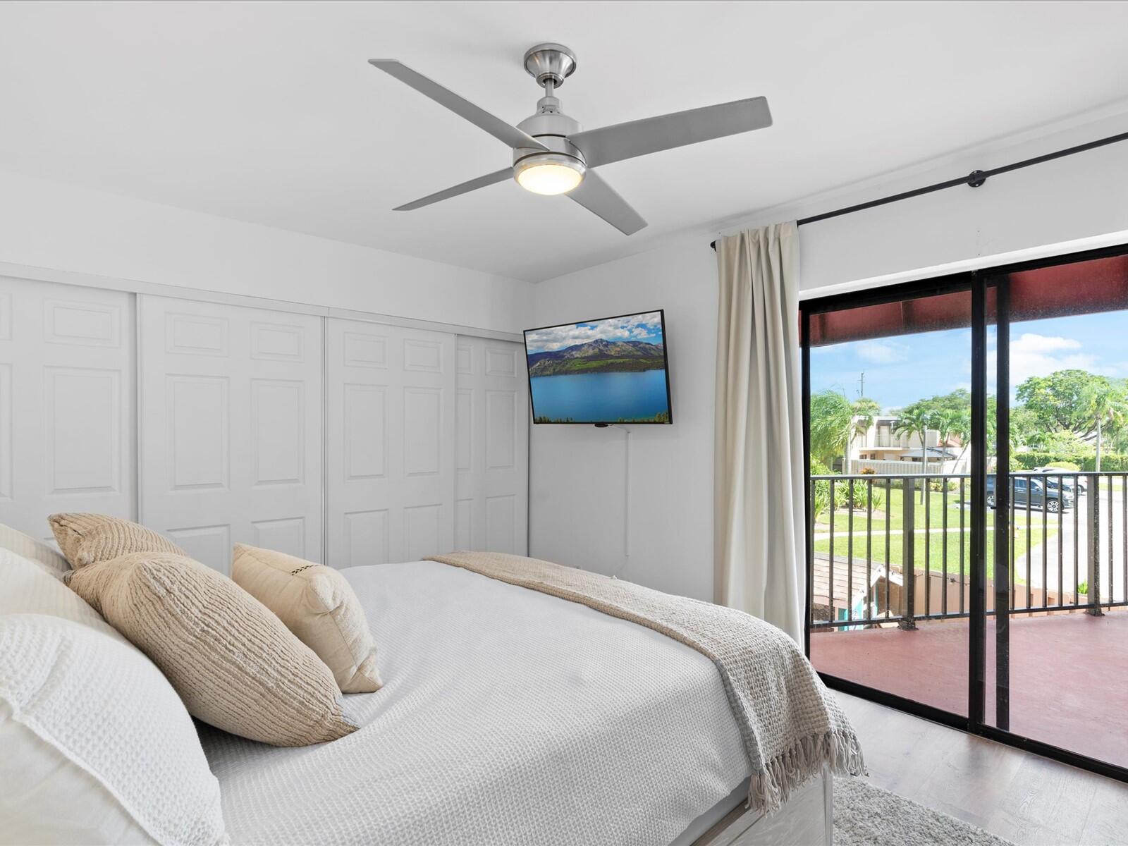 4025 Village Drive, Unit C Delray Beach, FL 33445 - Photo 13 of 32 a bedroom with a large bed and a large window