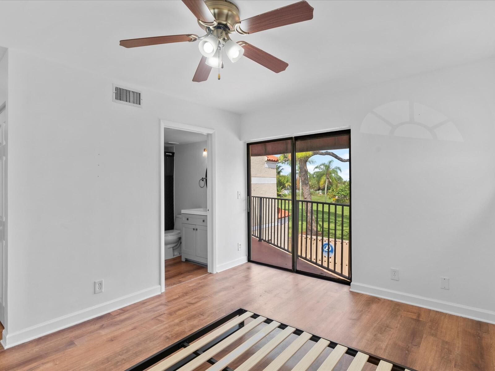 4025 Village Drive, Unit C Delray Beach, FL 33445 - Photo 19 of 32 an empty room with wooden floor fan and windows