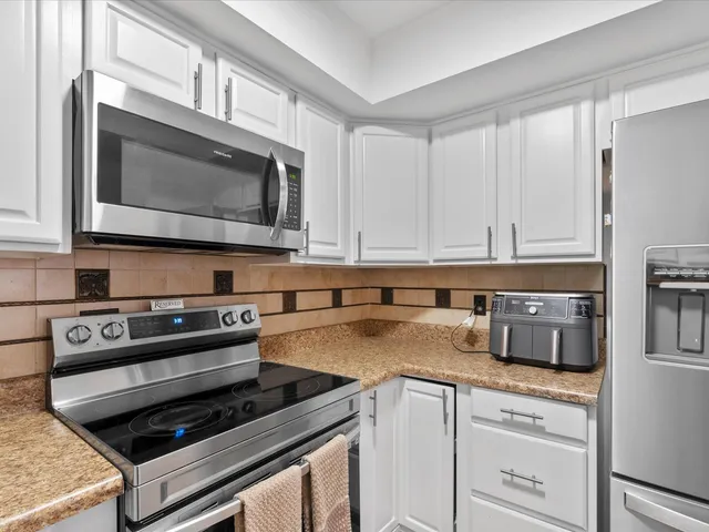 a kitchen with stainless steel appliances granite countertop a stove microwave and cabinets