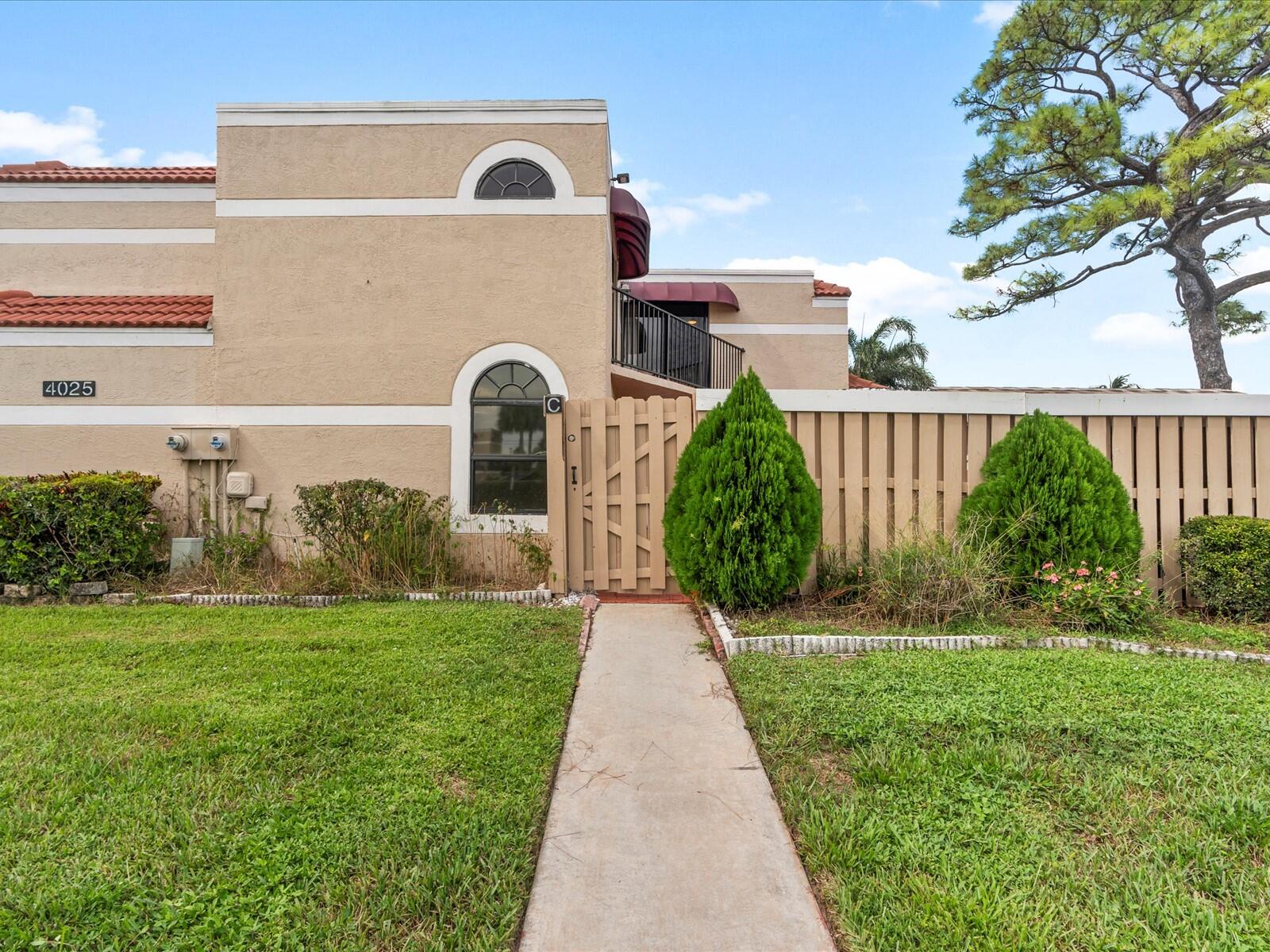4025 Village Drive, Unit C Delray Beach, FL 33445 - Photo 8 of 32 a front view of a house with garden