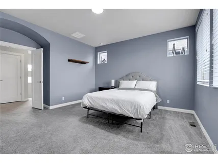 a spacious bedroom with a bed and a window