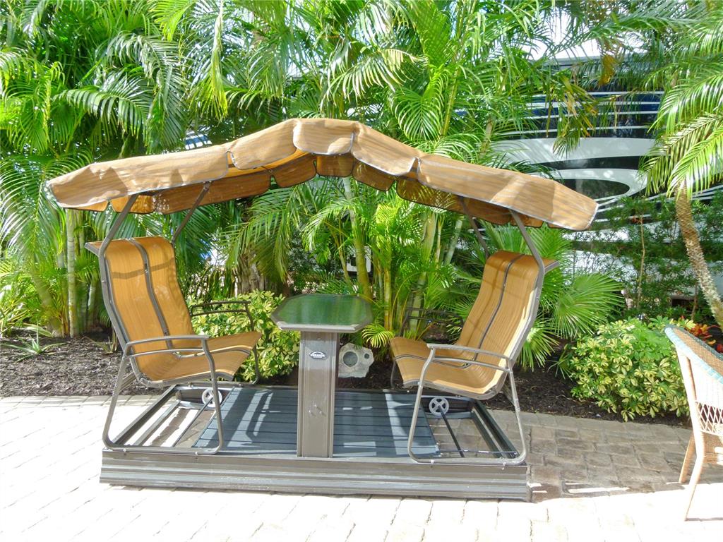 537 Southwest 40th Cove, Unit 73 Okeechobee, FL 34974 - Photo 11 of 23 a view of a patio with table and chairs and wooden floor