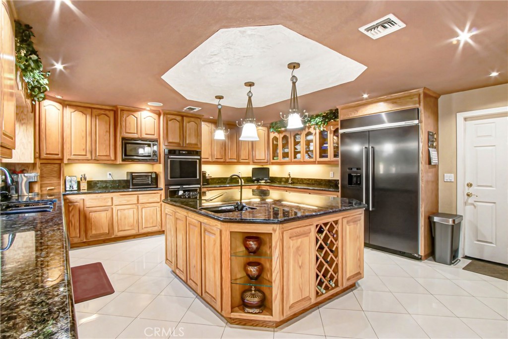 7954 Thoroughbred Street Rancho Cucamonga, CA 91701 - Photo 25 of 63 a kitchen with stainless steel appliances granite countertop a sink a stove and a refrigerator