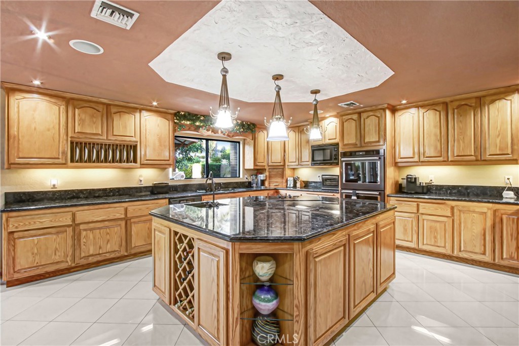7954 Thoroughbred Street Rancho Cucamonga, CA 91701 - Photo 26 of 63 a kitchen with stainless steel appliances granite countertop a sink a stove and cabinets