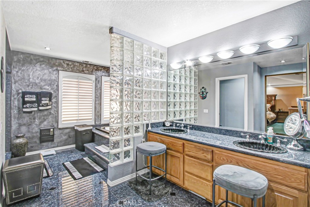 7954 Thoroughbred Street Rancho Cucamonga, CA 91701 - Photo 35 of 63 a spacious bathroom with a granite countertop tub and a large mirror