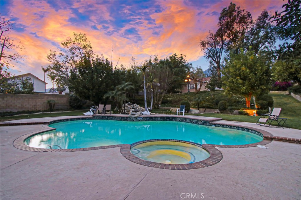 7954 Thoroughbred Street Rancho Cucamonga, CA 91701 - Photo 49 of 63 a view of a swimming pool with a yard and trees