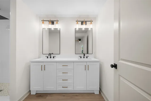 a bathroom with double vanity sinks and a mirror