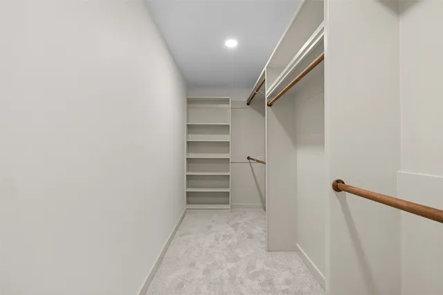 a view of walk in closet with empty racks