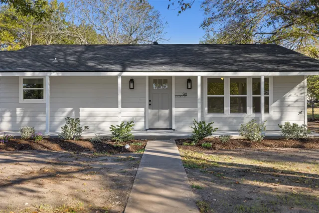 a front view of a house with potted plants